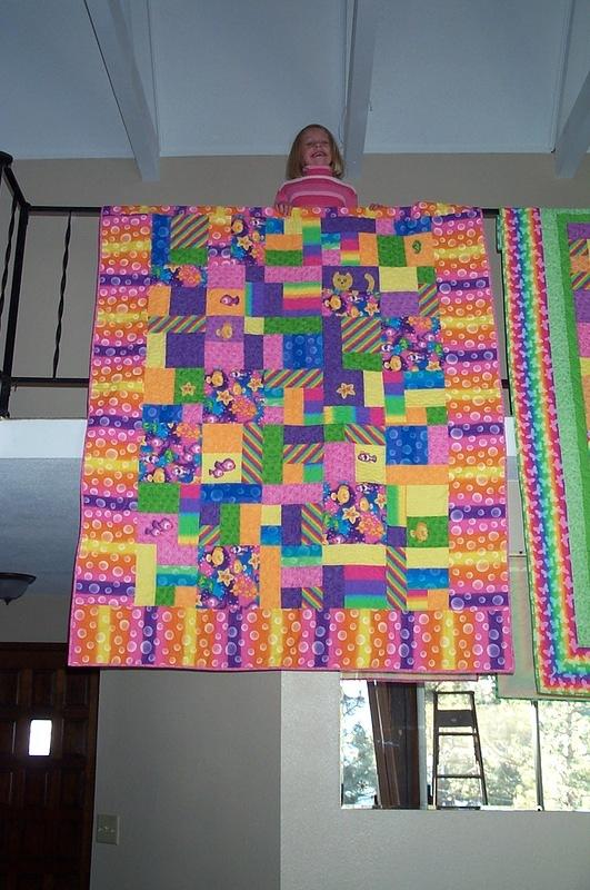 Hannah holds her quilt over the landing.