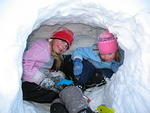 Elizabeth and Rebecca warming up in the little snow cave I dug in the hillside.