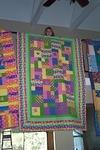 Rebecca holds her quilt over the landing.